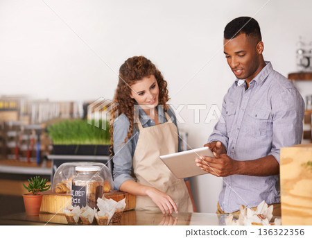 Tablet, coffee shop owner and teamwork of people, discussion and training. Waiters, black man and happy woman in restaurant with technology for inventory, stock check or managing sales in store. Tablet, coffee shop owner and teamwork of people, discussion and training. Waiters, black man and happy woman in restaurant with technology for inventory, stock check or managing sales in store. 136322356