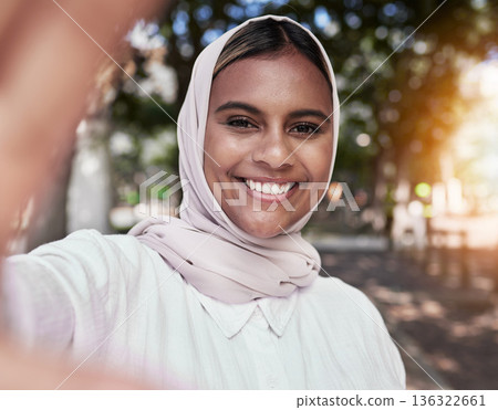 Selfie, happy and portrait of Muslim woman in park for holiday, freedom and relax outdoors. Social media, hijab and face of Islamic female person with smile for picture, memories and post in nature 136322661