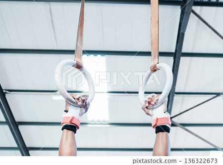 Hands, gymnastics ring and person in fitness for workout, strength training or competition. Closeup of hanging athlete, strong gymnast or acrobat holding on balance circles for performance exercise 136322673