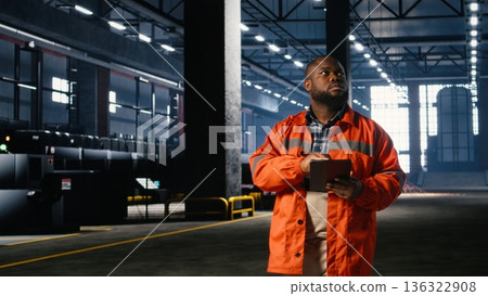 Industrial engineer manages equipment to ensure operation tasks on the factory floor, demonstrating workforce coordination and reviewing industrial machinery. Advanced technology. Industrial engineer manages equipment to ensure operation tasks on the factory floor, demonstrating workforce coordination and reviewing industrial machinery. Advanced technology. 136322908
