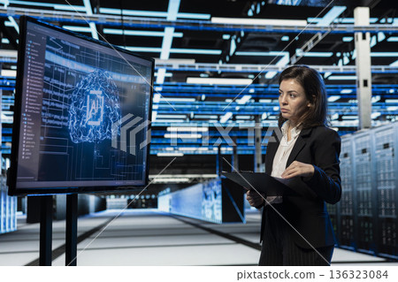 Data center computer scientist using AI to troubleshoot backend operations gear. Server hub worker running deep learning software development program on large display, resolving system crashes 136323084