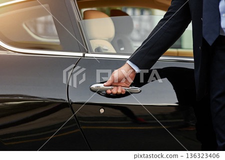 Businessman, hands and chauffeur by car door for travel accommodation, designated driver or commute. Hand of male person on vehicle handle in professional transport service, business class or pick up Businessman, hands and chauffeur by car door for travel accommodation, designated driver or commute. Hand of male person on vehicle handle in professional transport service, business class or pick up 136323406