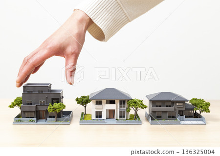 Woman's hand choosing a house 136325004
