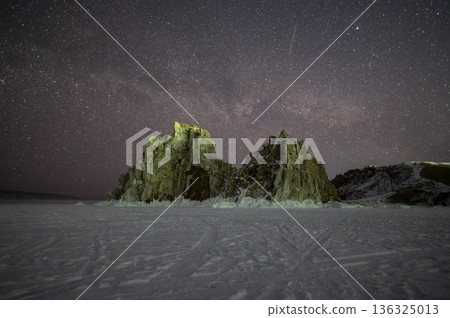 The Shaman rock one of sacred place in frozen lake Baikal in winter season of Siberia, Russia at night. This rock is a subject of many popular legends and myths about Baikal Lake and Angara river. The Shaman rock one of sacred place in frozen lake Baikal in winter season of Siberia, Russia at night. This rock is a subject of many popular legends and myths about Baikal Lake and Angara river. 136325013