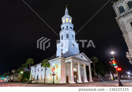 St Michaels Church in Charleston, South Carolina, USA. Historic white colonial architecture features a tall steeple and portico on Broad Street at night St Michaels Church in Charleston, South Carolina, USA. Historic white colonial architecture features a tall steeple and portico on Broad Street at night 136325155