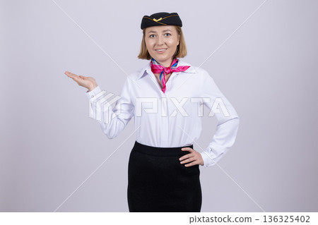 Stewardess in aviation uniform presenting copy space 136325402