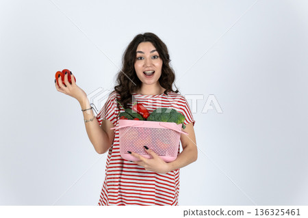 Woman holding basket with apples and red fruit 136325461
