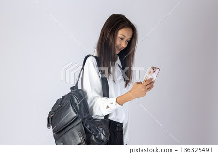 Woman walking and using smartphone in studio Woman walking and using smartphone in studio 136325491