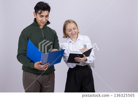 Young man and woman in uniform holding a blue folder Young man and woman in uniform holding a blue folder 136325505