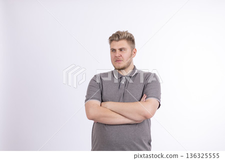 Confident young man standing with arms crossed looking ahead Confident young man standing with arms crossed looking ahead 136325555