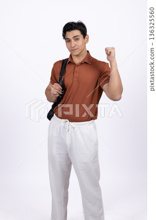 Man in orange polo shirt walking with blazer on shoulder Man in orange polo shirt walking with blazer on shoulder 136325560