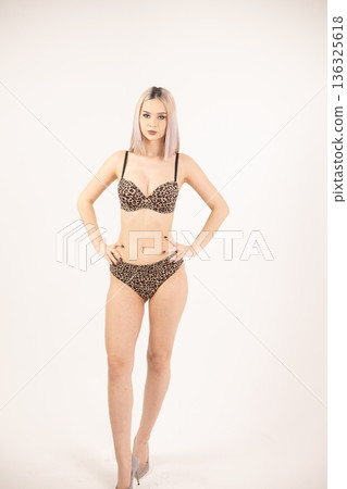 Confident young woman standing straight with hands on her hips Confident young woman standing straight with hands on her hips 136325618