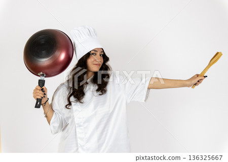 Woman cook holding pan and rolling pin in studio Woman cook holding pan and rolling pin in studio 136325667