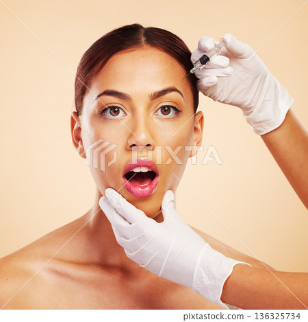 Surprise, woman or face in plastic surgery injection for facelift or cosmetics isolated on studio background. Forehead portrait, wow or shocked model with needle for skin beauty in medical procedure 136325734