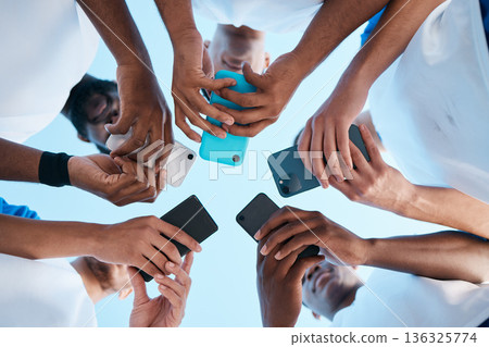 Hands, phone and app with people in a huddle or circle for communication or connectivity. Mobile, social media or information sharing with a group of men networking together closeup from below 136325774