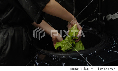 Hands washing fresh green lettuce in the kitchen Hands washing fresh green lettuce in the kitchen 136325797