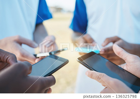 Hands, phone and networking with sports people in a huddle for communication or connectivity. Mobile, social media or information sharing with a person group standing in a circle closeup outdoors Hands, phone and networking with sports people in a huddle for communication or connectivity. Mobile, social media or information sharing with a person group standing in a circle closeup outdoors 136325798