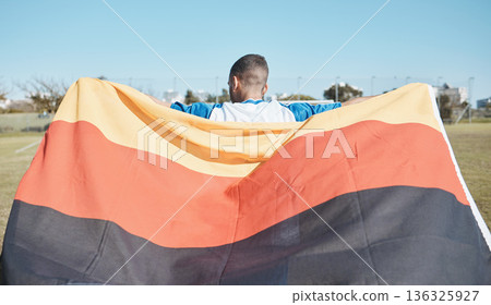 Germany, sports and man with a flag for soccer, motivation and training on a field. Back, fitness and professional athlete or person with representation of a country at a football game or competition Germany, sports and man with a flag for soccer, motivation and training on a field. Back, fitness and professional athlete or person with representation of a country at a football game or competition 136325927