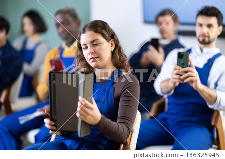 Girl worker take photos of presentation slide or scan QR code in classroom Girl worker take photos of presentation slide or scan QR code in classroom 136325945