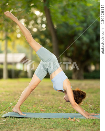 Adult woman doing yoga in park Adult woman doing yoga in park 136326115