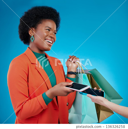Phone, machine and woman in shopping bag, POS and online payment, digital service or fashion fintech. Retail, mobile and cashier, african customer or people at point of sale on blue studio background Phone, machine and woman in shopping bag, POS and online payment, digital service or fashion fintech. Retail, mobile and cashier, african customer or people at point of sale on blue studio background 136326258