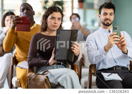 Girl participants take photos of presentation slide or scan QR code 136326263