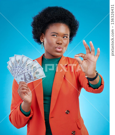 Money, okay sign and woman thinking of success, profit and sales deal with yes emoji on blue background. Financial ideas of rich, african person for cash, lottery goals or bonus achievement in studio 136326431