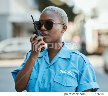 Woman, radio and a security guard or safety officer outdoor on a city road for communication. Black person talking on walkie talkie on urban street to report crime for investigation and surveillance Woman, radio and a security guard or safety officer outdoor on a city road for communication. Black person talking on walkie talkie on urban street to report crime for investigation and surveillance 136326480