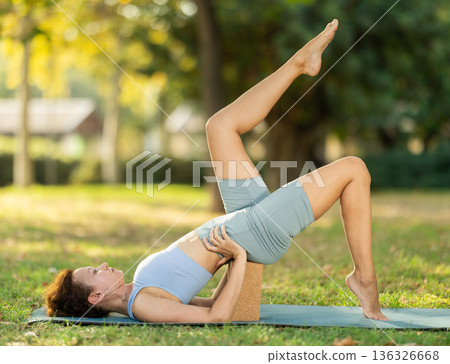 Adult woman doing yoga with blocks 136326668
