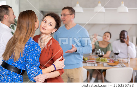 Happy middle-aged pair welcoming their guests at home 136326788