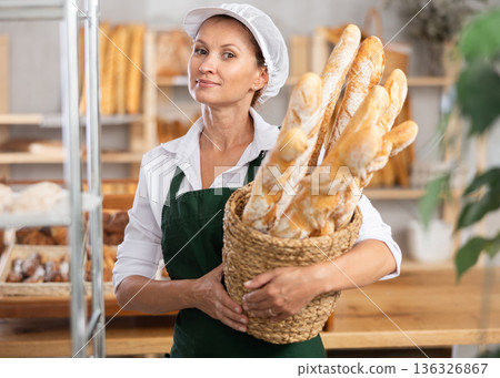 Positive female seller showing assortment of bakery Positive female seller showing assortment of bakery 136326867