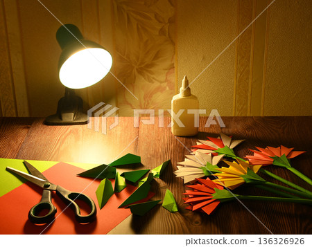 origami paper flowers and tools on a wooden table 136326926