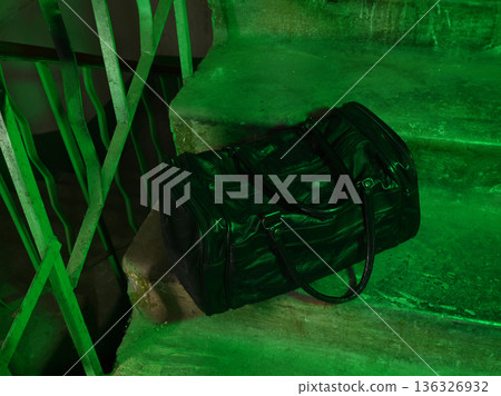 black leather bag on a concrete staircase in green light black leather bag on a concrete staircase in green light 136326932