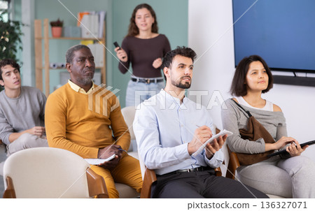 Multinational group listens and takes notes lectures in lecture hall 136327071