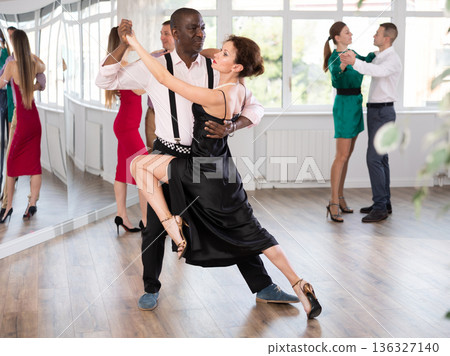 Middle-aged man and woman practicing waltz in dancing studio 136327140
