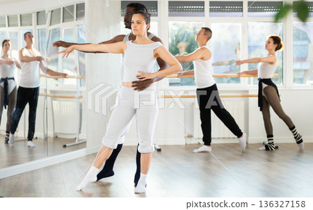 Asian female amateur ballet dancer mastering partnered dance in studio Asian female amateur ballet dancer mastering partnered dance in studio 136327158