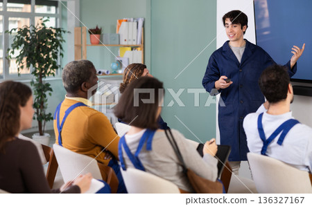 Young man teacher gives lecture to group in lecture hall Young man teacher gives lecture to group in lecture hall 136327167