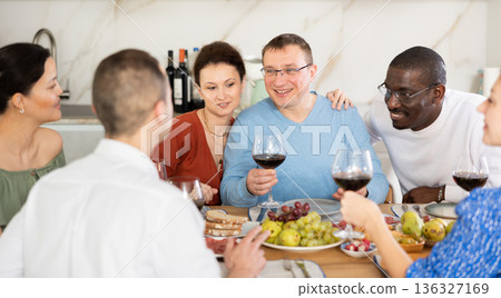 Multiethnic women and men friends chatting and drinking Multiethnic women and men friends chatting and drinking 136327169