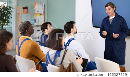 Middle aged man worker lecturer speaks to audience of listeners Middle aged man worker lecturer speaks to audience of listeners 136327219