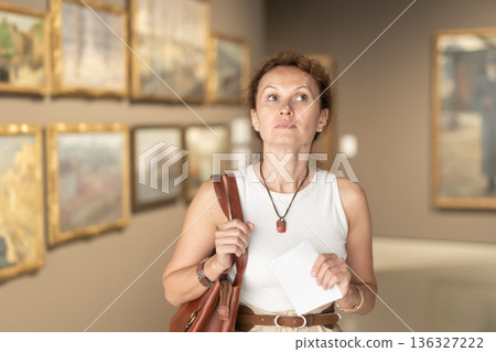 Intelligent woman visiting painting exhibition at museum Intelligent woman visiting painting exhibition at museum 136327222