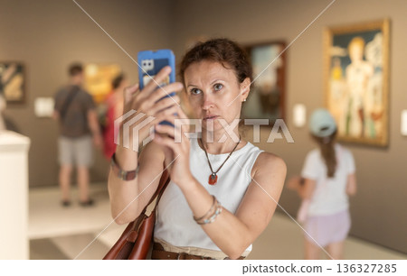 Adult woman taking photo of art gallery 136327285