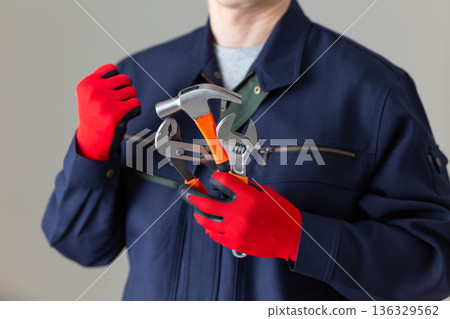 一位身穿工作服、手持工具的中年男性商人 136329562