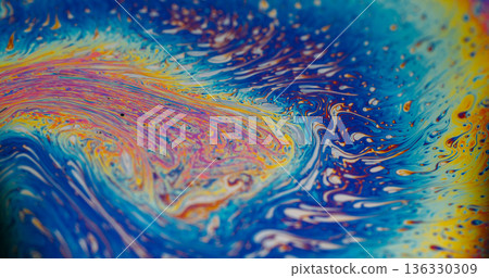 Defocused rainbow soap. Colorful ink blob. Yellow orange liquid splash on blue background. Bright art gasoline dye abstract wave blend. 136330309