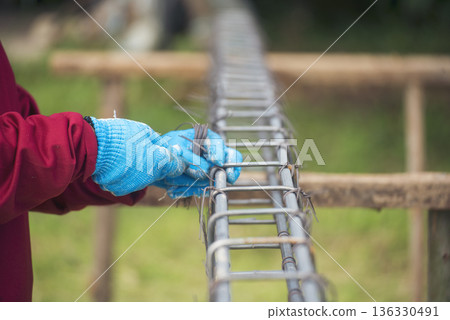 Construction Men hands bending cutting steel wire fences bar reinforcement of concrete work. Worker hands using pincer pliers iron wire. Outdoor Worker using wire bending pliers, construction work 136330491