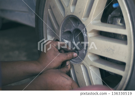 Mechanic man hands checking car tires outdoor on site service auto garage for automotive mobile center services. Technician workshop repair checking tyres car motor vehicles service mechanical hands 136330519