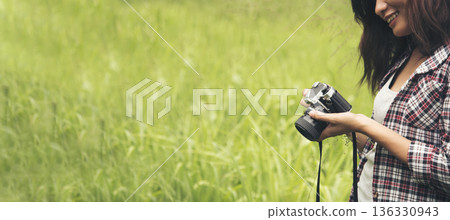Banner Asian Women with vintage film camera take a photo. Panorama female photographer look at photo from professional camera outdoor. Young woman shooting photo in green nature park with copy space Banner Asian Women with vintage film camera take a photo. Panorama female photographer look at photo from professional camera outdoor. Young woman shooting photo in green nature park with copy space 136330943