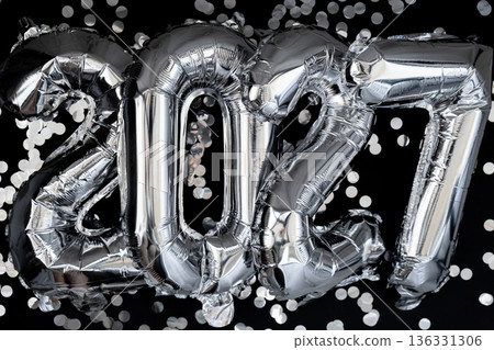 Happy new year 2027 metallic balloons with confetti on dark black background. Greeting card silver foil balloons numbers Christmas holiday concept. Celebration party congratulation Happy new year 2027 metallic balloons with confetti on dark black background. Greeting card silver foil balloons numbers Christmas holiday concept. Celebration party congratulation 136331306