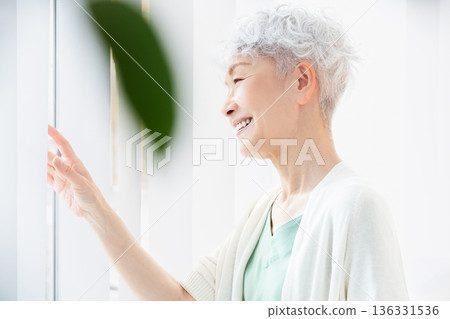 清晨，一位老婦人在窗邊消磨時光。 136331536