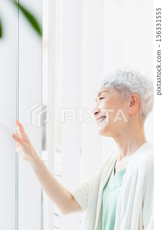 Senior woman spending time by the window in the morning Senior woman spending time by the window in the morning 136331555