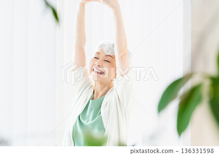 Senior woman spending time by the window in the morning Senior woman spending time by the window in the morning 136331598